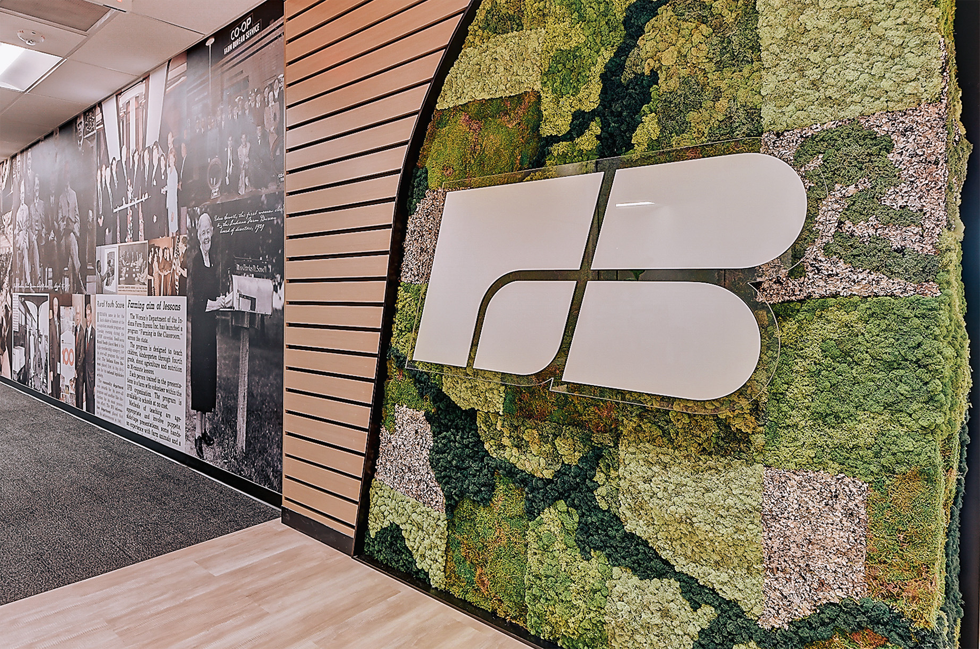 Farm Bureau logo on a wall covered in moss and a historical photo collage.