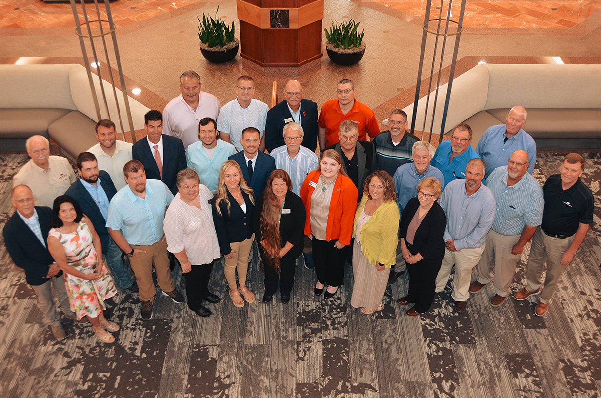 A group of people smiling up at a bird's-eye view.