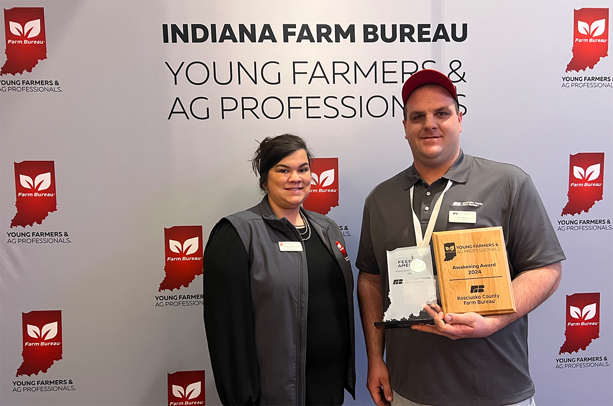 Two adults posing with awards.